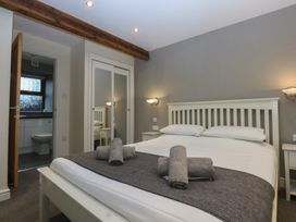 A bedroom with a bed and nightstand at Llofft Yr Yd in Porthmadog