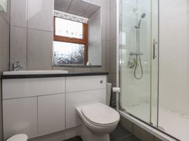 A bathroom with a sink, toilet, and shower at Llofft Yr Yd, Porthmadog