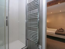 A shower with a towel radiator in a bathroom at Llofft Yr Yd in Porthmadog