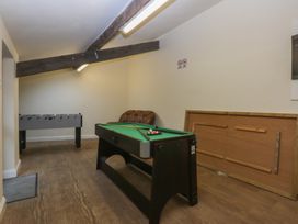 A game room with a pool table and foosball table at Llofft Yr Yd in Porthmadog