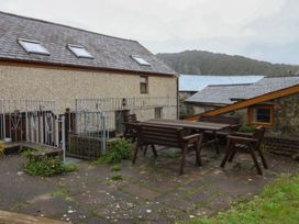 An outdoor area with a table and chairs at Llofft Yr Yd in Porthmadog