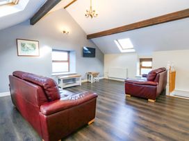 A living room with sofas and a table at Llofft Yr Yd Porthmadog