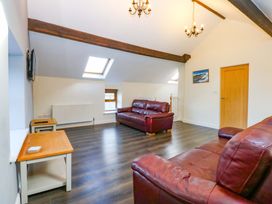 A living room with two sofas and a television at Llofft Yr Yd in Porthmadog