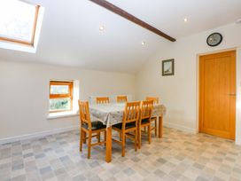 A dining room with a table and chairs at Llofft Yr Yd in Porthmadog