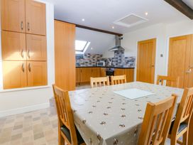 A kitchen with a dining table and chairs at Llofft Yr Yd in Porthmadog