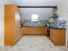 A kitchen with cabinets and appliances at Llofft Yr Yd in Porthmadog
