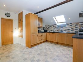 A kitchen with cabinets, sink and countertop at Llofft Yr Yd in Porthmadog
