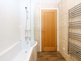 A bathroom featuring a bathtub, shower and towel radiator at Llofft Yr Yd Porthmadog