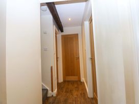 A hallway with doors on both sides and a staircase at Llofft Yr Yd in Porthmadog