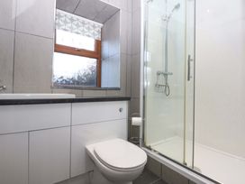 A bathroom with a toilet, sink, and shower at Llofft Yr Yd in Porthmadog