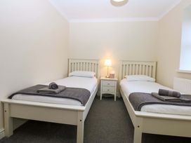 A bedroom with two twin beds and a nightstand at Llofft Yr Yd in Porthmadog
