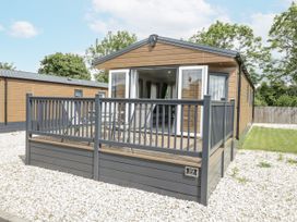 A cabin with a deck and chairs at Serendipity