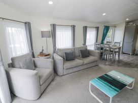 A living room with sofa and dining area at Serendipity