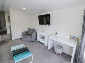 A living room with a sofa and a television at Serendipity