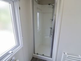 A shower enclosure with a window and towel rail at Serendipity