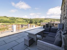 An outdoor area with seating and a table at Plas Glan Yr Afon in Llangernyw