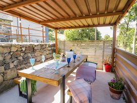 An outdoor dining area with a table and drinks at Plas Glan Yr Afon in Llangernyw