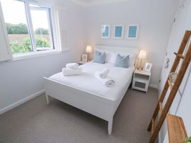 A bedroom with a bed and window at Trelowen in St Issey near Padstow
