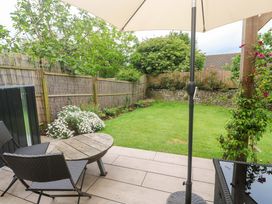 A garden with seating and an umbrella at Trelowen St Issey near Padstow