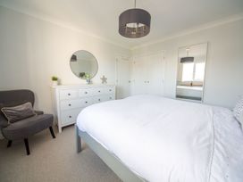 A bedroom with a bed and dresser at Trelowen St Issey near Padstow