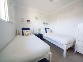 A bedroom with two beds and a nightstand at Trelowen St Issey near Padstow