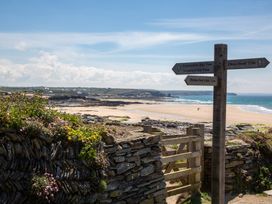 A beach scene with a signpost showing directions at Trelowen St Issey near Padstow