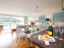 A living room with a table, champagne, and croissants at Villa 1, Estura, Salcombe