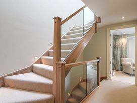 A staircase with carpet and glass panels at Villa 1, Estura in Salcombe