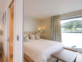 A bedroom with a bed and a window view at Villa 1, Estura Salcombe