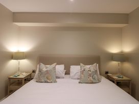 A bedroom with a bed and bedside lamps at Villa 1, Estura Salcombe