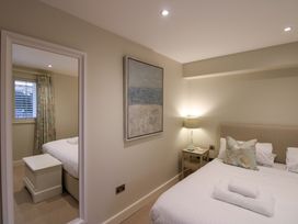 A bedroom with a bed and painting at Villa 1, Estura Salcombe