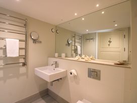 A bathroom with a sink and towel rack at Villa 1, Estura, Salcombe