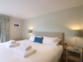 A bedroom with a bed and towels on top at Villa 1, Estura Salcombe