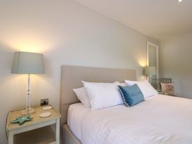 A bedroom with a bed and lamp at Villa 1, Estura, Salcombe