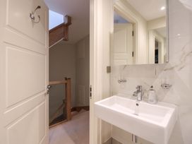 A bathroom with a sink and mirror at Villa 1, Estura Salcombe