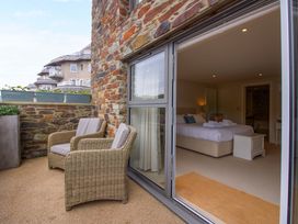 A balcony with chairs overlooking a bedroom at Villa 1, Estura in Salcombe