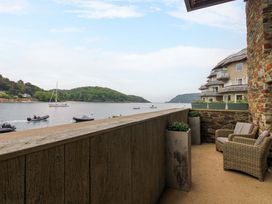 A balcony with chairs and planters overlooking the river at Villa 1, Estura in Salcombe