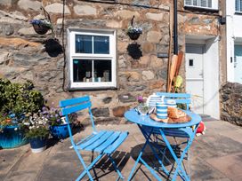 A table and chairs with food and drink at Gerallt in Morfa Nefyn