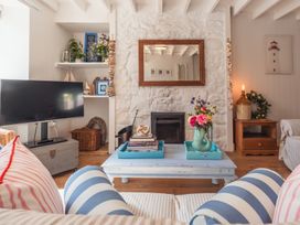 A living room with a coffee table and a television at Gerallt in Morfa Nefyn