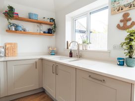 A kitchen with wooden shelves and a sink at Gerallt in Morfa Nefyn