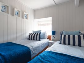 A bedroom with two beds and a nightstand at Gerallt in Morfa Nefyn