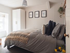 A bedroom with a bed and wardrobe at Gerallt in Morfa Nefyn