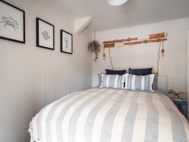 A bedroom with a bed and wall decor at Gerallt in Morfa Nefyn