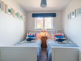 A bedroom with two single beds and a lamp at Gerallt in Morfa Nefyn