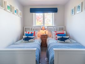 A bedroom with two single beds and a nightstand at Gerallt in Morfa Nefyn