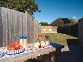 A garden with a table set for outdoor dining at Gerallt in Morfa Nefyn