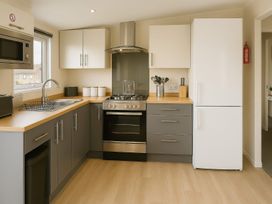 A kitchen with a sink and stove at Birch Lodge in Warton near Carnforth