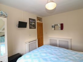 A bedroom with a bed, television, and wardrobe at Waterfall House in Dunmanway, County Cork