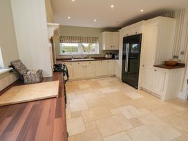 A kitchen with cabinets, sink and fridge at Wyvill House in Cayton