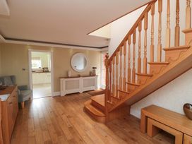 A hallway with a staircase and a console table at Wyvill House in Cayton